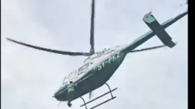 Man clings in helicopter
