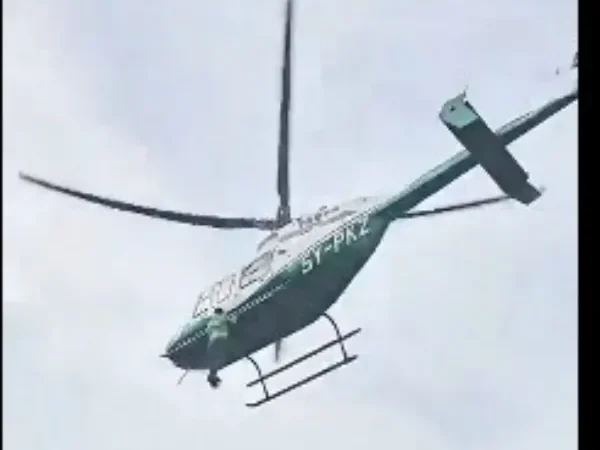 Man clings in helicopter