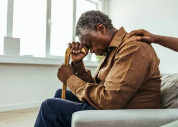 Senior man being cared for by a young nurse in a retirement home