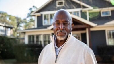 Portrait of senior man in front of his house