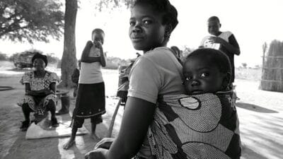 Woman carrying baby on husband funeral day