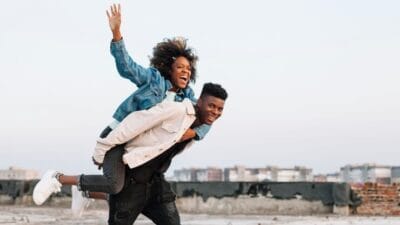 Teenager carrying young girl outdoors