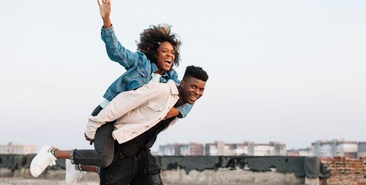 Teenager carrying young girl outdoors