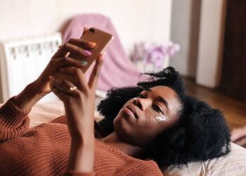 Lady watching on her phone in bed