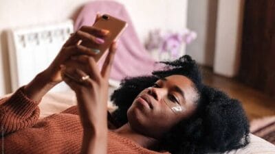 Lady watching on her phone in bed