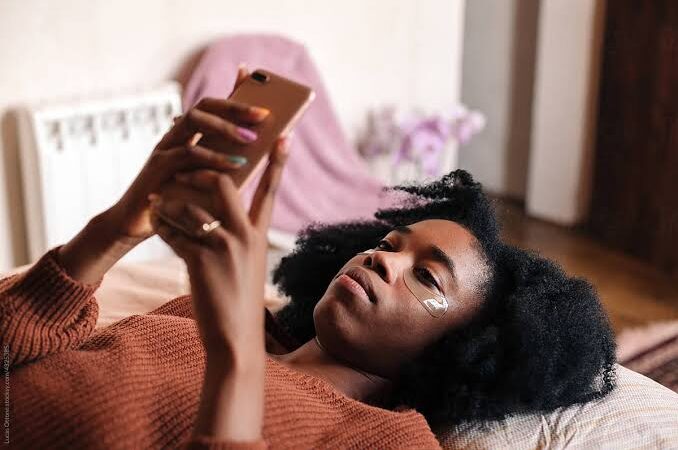 Lady watching on her phone in bed