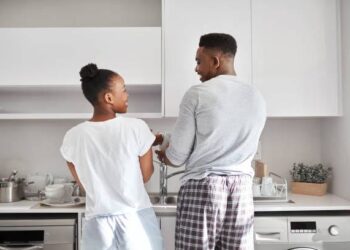 Man and woman washing utensil in the kitchen photo