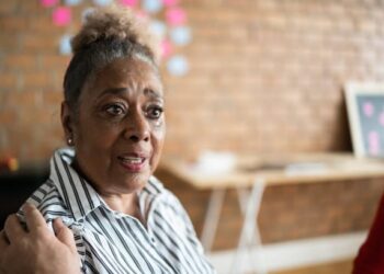 Senior woman talking and crying in group therapy