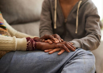 A woman with cancer and her daughter hand in hand.