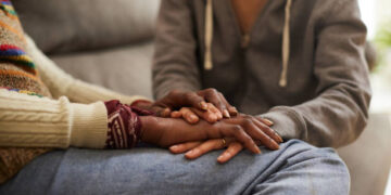A woman with cancer and her daughter hand in hand.