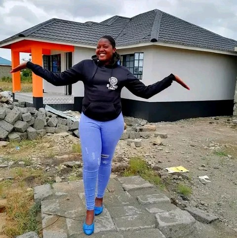 Businesslady Kathy Andrews behind Omosh house photo