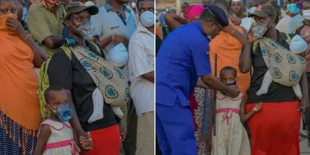 Coast Region Police Commander Rashid Yakub  helping a child with face-mask