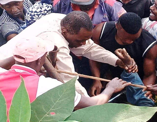 Mukinduri villagers taking a woman from a well